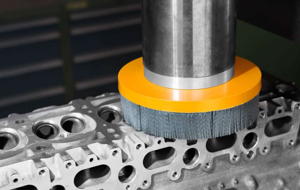 Spazzola ATB al lavoro su una testata motore. Scegliendo una grana abrasiva opportuna è possibile fornire un valore di finitura superficiale corretto per impedire trafilamenti della guarnizione, preservandone al tempo stesso l'integrità