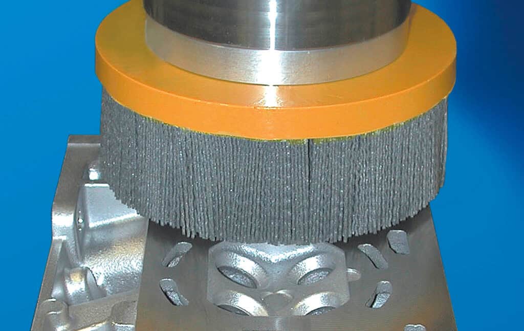 Spazzola ATB al lavoro su una testata motore. Scegliendo una grana abrasiva opportuna è possibile fornire un valore di finitura superficiale corretto per impedire trafilamenti della guarnizione, preservandone al tempo stesso l'integrità