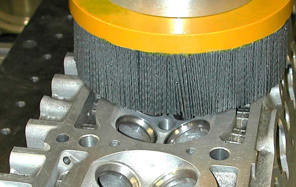 Spazzola ATB al lavoro su una testata motore. Scegliendo una grana abrasiva opportuna è possibile fornire un valore di finitura superficiale corretto per impedire trafilamenti della guarnizione, preservandone al tempo stesso l'integrità