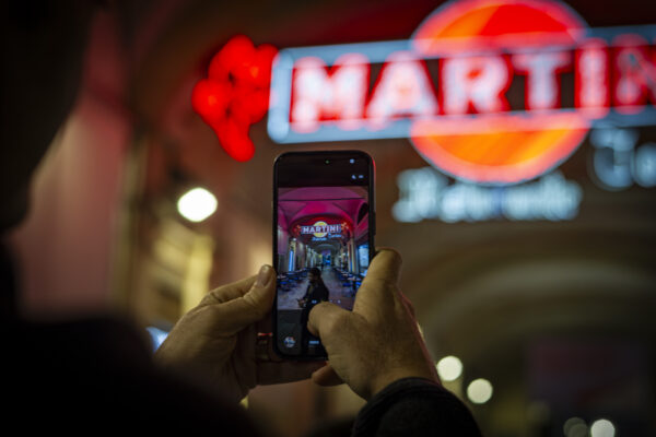 Iconica insegna luminosa della Martini e Rossi, sotto i portici di Piazza San Carlo a Torino